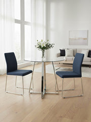 Silver base round glass dining table in a dining room setting with chairs