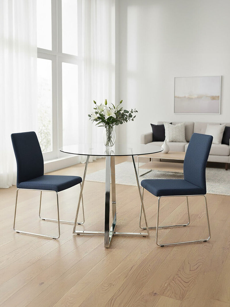 Silver base round glass dining table in a dining room setting with chairs