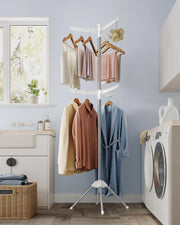 Clothes airer drying shirts and towels in a blue laundry room beside a washing machine