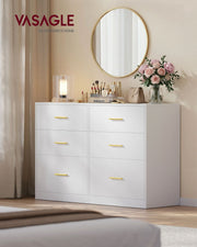 White 6 drawer chest in a bedroom with a round gold mirror and make-up on top