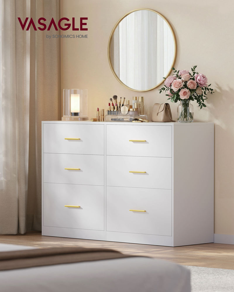 White 6 drawer chest in a bedroom with a round gold mirror and make-up on top