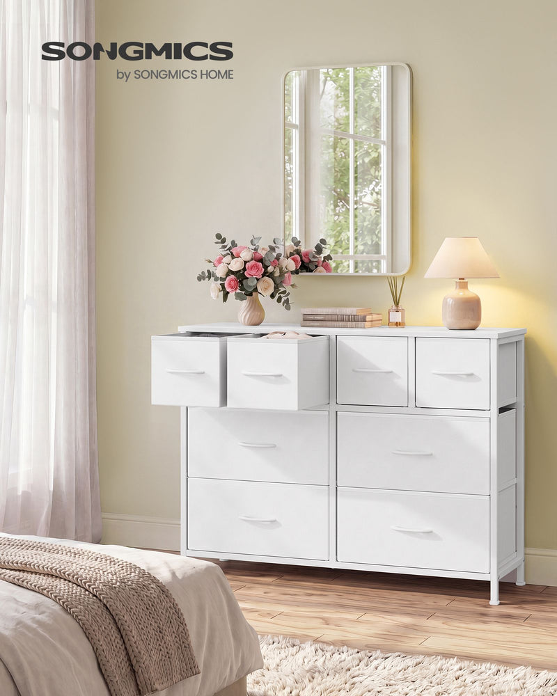Cloud white 8 drawer fabric chest in a bedroom with top drawers open beside a mirror and lamp
