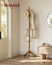 Wooden coat rack stand by a hallway front door holding a hat, coat and handbag