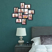 Black collage frame on a dark green bedroom wall above a bedside table lamp