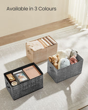 Storage boxes on a bedroom floor holding books, toys and folded clothes