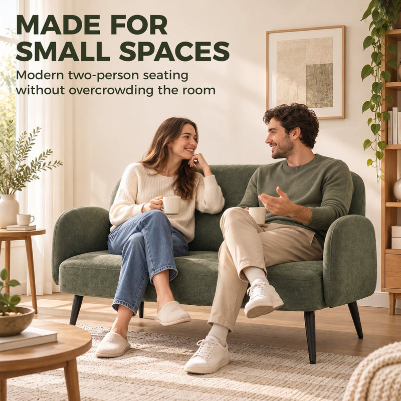 Couple sitting together on the green sofa in a small living room