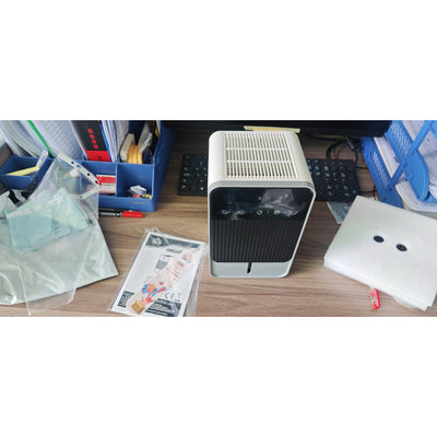 HOMCOM compact dehumidifier on a desk with instruction manual and accessories