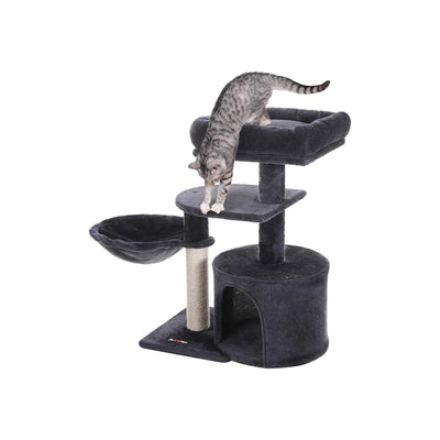 Cat resting inside the cave at the base of the cat tree