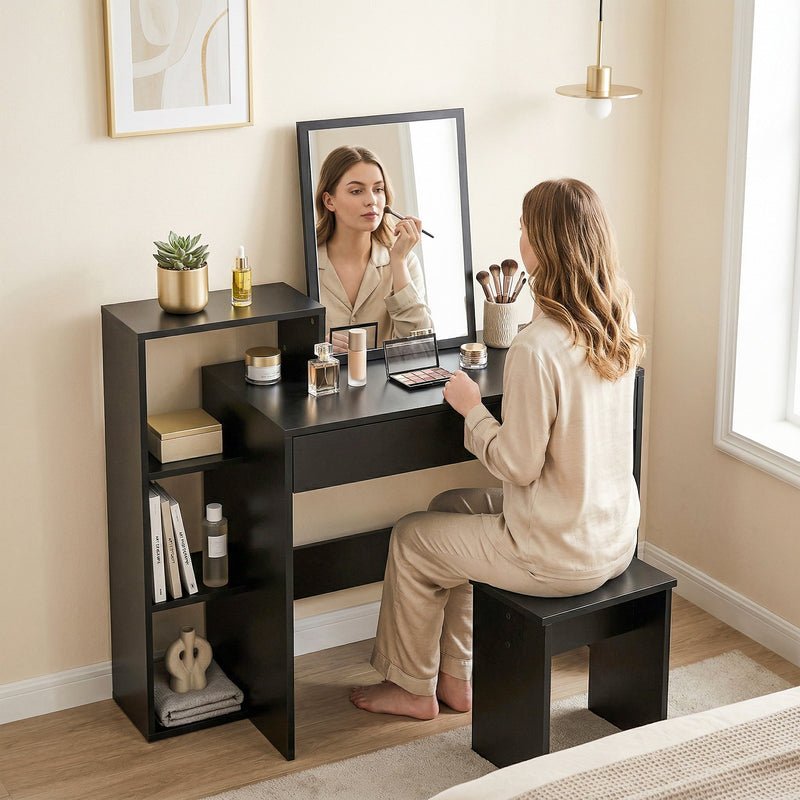 Woman seated at the black desk using it as a dressing table with a mirror