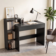 Black desk with a desk lamp, clock and books in a bright room with a plant