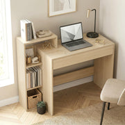 Natural computer desk in a bedroom with a laptop, books and a lamp on top