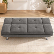 Grey convertible sofa bed laid flat in a bright living room
