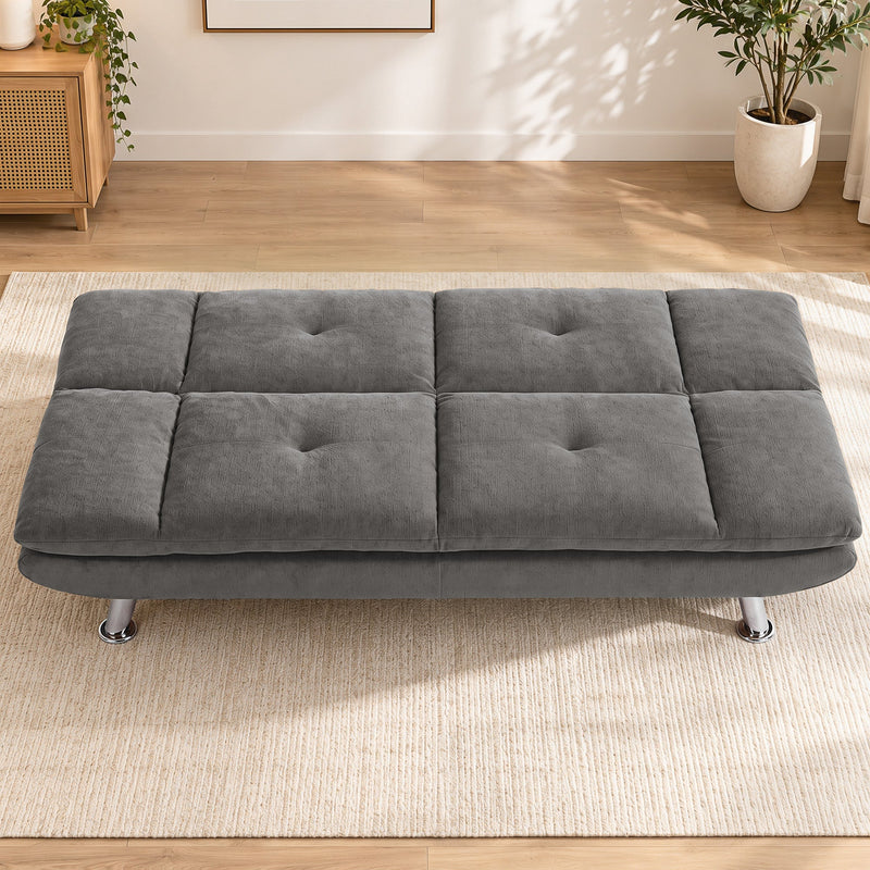 Grey convertible sofa bed laid flat in a bright living room
