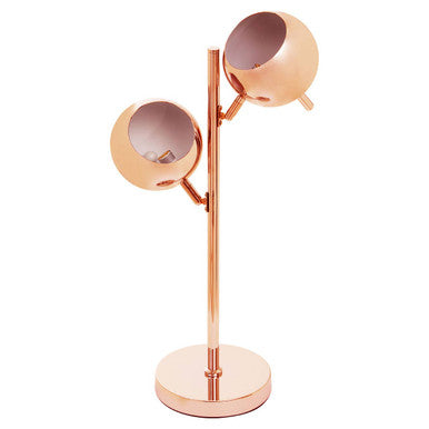 Copper table lamp with two round shades on a plain background