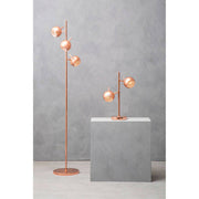 Copper two light table lamp on a bedside table