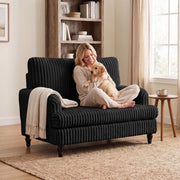 Woman hugging a puppy in the armchair with a knitted throw over the arm