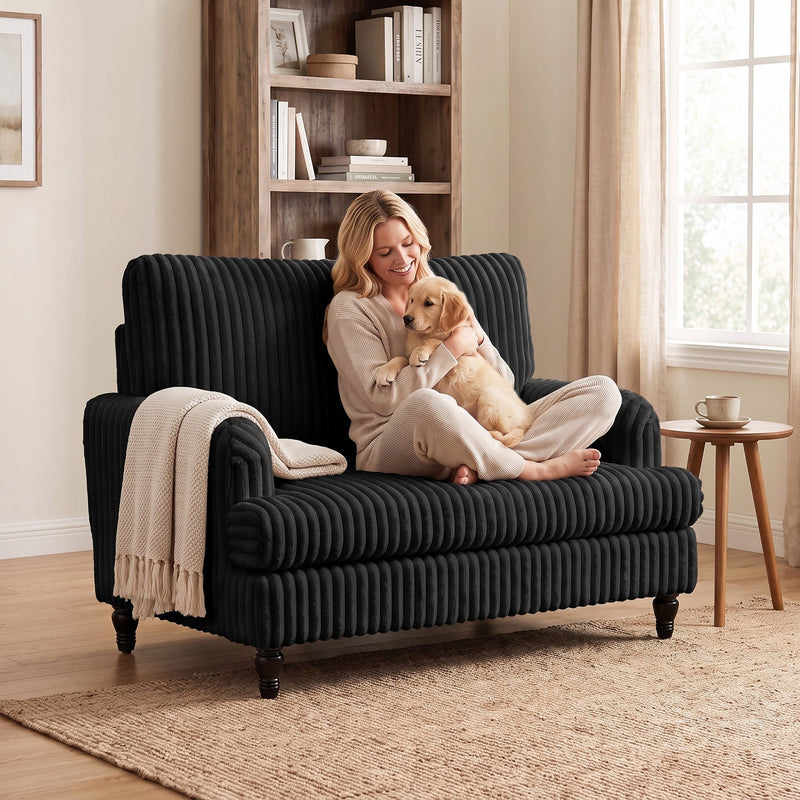 Woman hugging a puppy in the armchair with a knitted throw over the arm