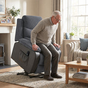 Man rising from the raised power lift recliner in a living room