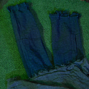 Close-up of the denim legs and grey fabric body of the crawling zombie prop on grass