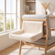 Cream cat bed hooked over the back of a wooden armchair