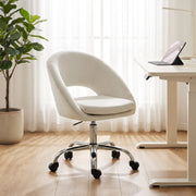 Cream desk chair beside a height-adjustable desk with a potted plant