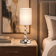 Bedside table lamp lighting a bedroom corner beside the bed