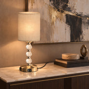 Lamp glowing on a console table in front of abstract artwork
