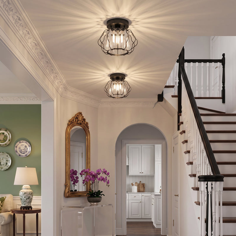 Crystal ceiling lights in a hallway next to a staircase with a mirror and orchids