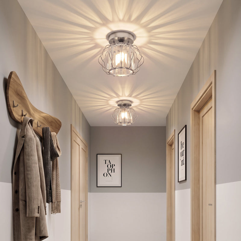 Corridor lit by two crystal ceiling lights with a coat rack on the wall