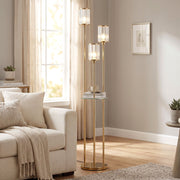 Gold tone floor lamp beside a cream armchair next to a window