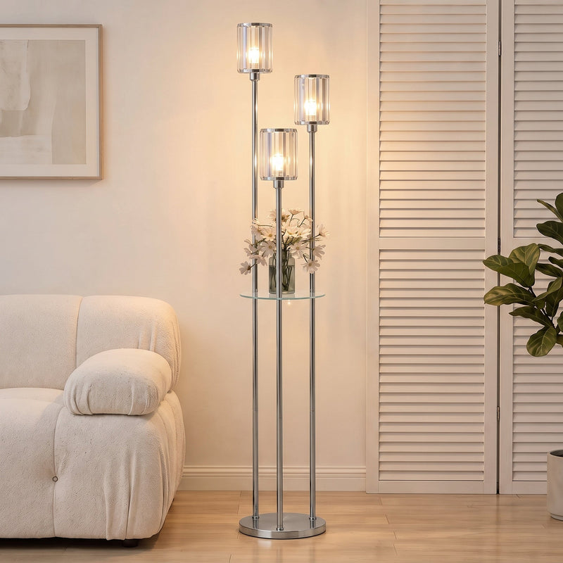 Chrome floor lamp with 3 crystal shades lit beside a cream sofa and louvre doors