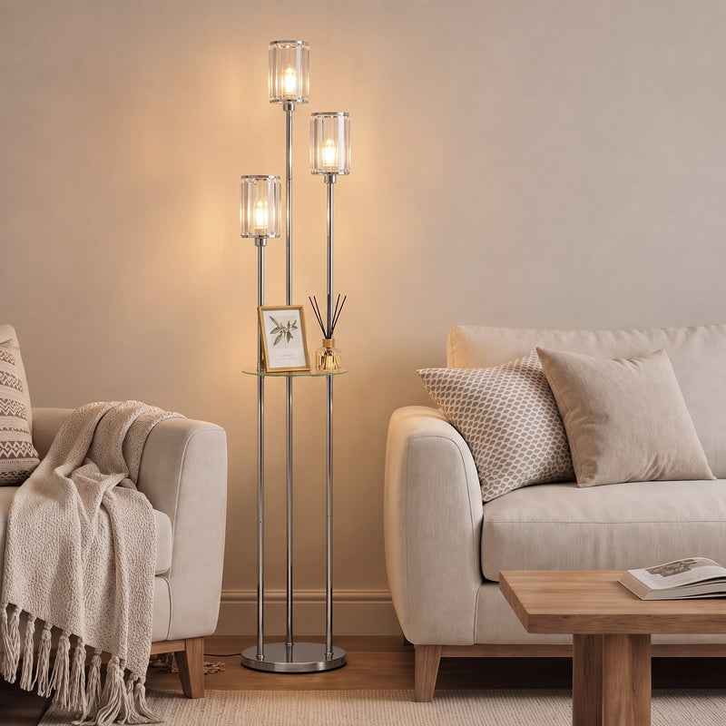 Chrome floor lamp with glass shelf beside a sofa and coffee table in a living room