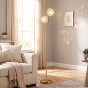Gold crystal globe floor lamp lit beside a cream sofa in a living room
