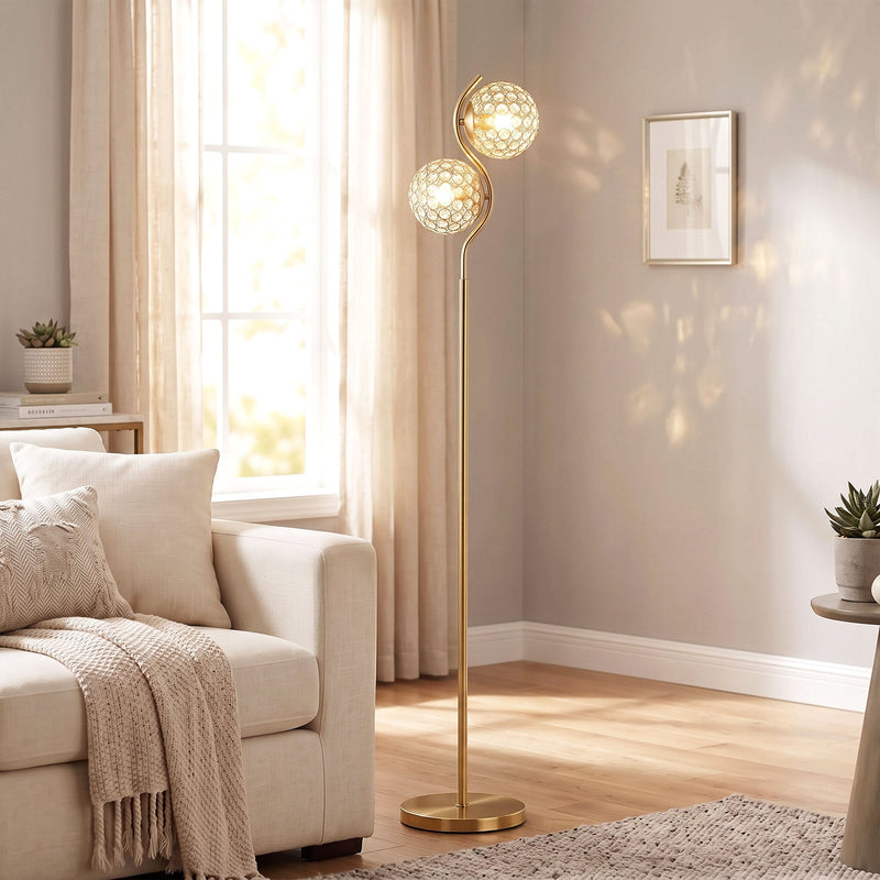 Gold crystal globe floor lamp lit beside a cream sofa in a living room