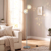 Silver crystal globe floor lamp lit beside a cream sofa in a living room