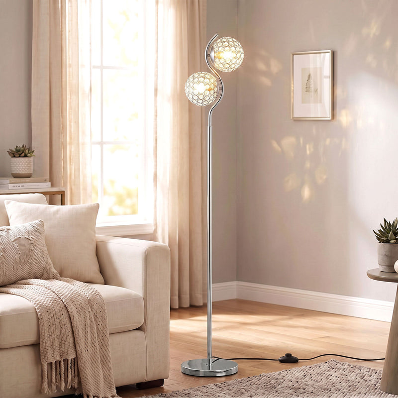 Silver crystal globe floor lamp lit beside a cream sofa in a living room