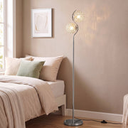 Silver crystal globe floor lamp in a bedroom corner next to a bed and window