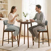Couple having coffee at a round table on two grey bar stools
