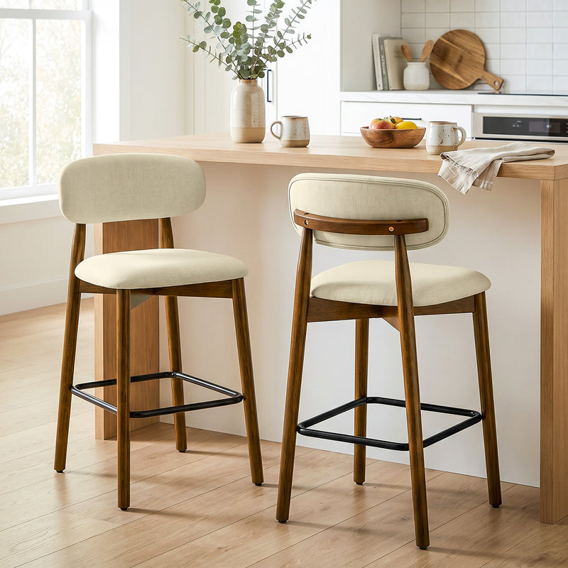 Pair of beige bar stools at a kitchen island with a bowl of fruit