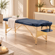 Dark blue massage table set up in a treatment room with a folded towel