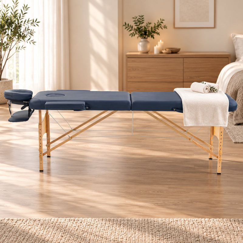 Side view of the dark blue massage table in a bright treatment room