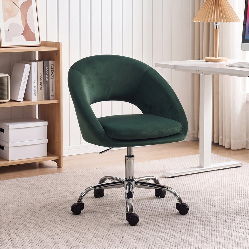 Dark green velvet desk chair in a home office with a bookcase and adjustable desk