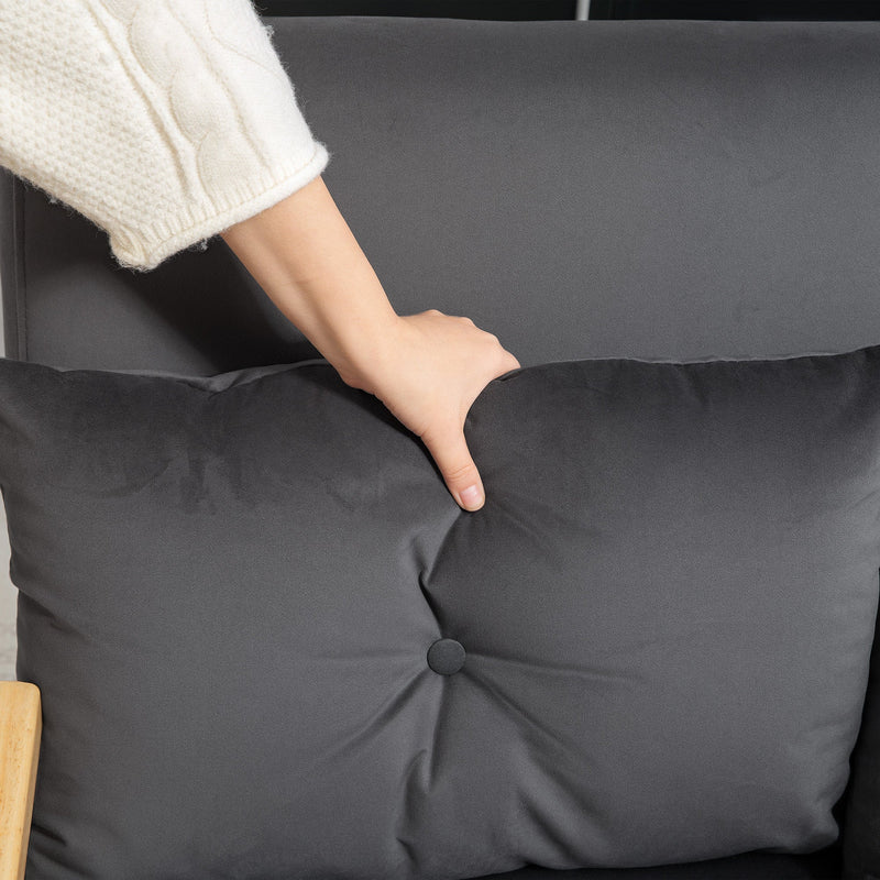 Close-up of a hand pressing into the tufted velvet cushion