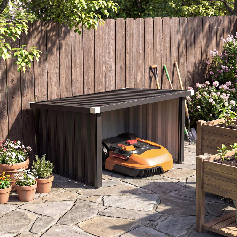 Robot mower garage beside a wooden fence with an orange robotic mower inside