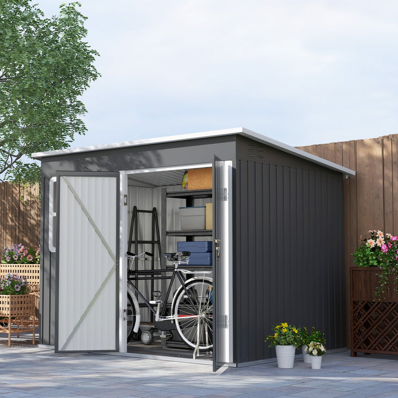The metal shed in a paved garden with both doors open, showing a bike, shelving and storage boxes inside