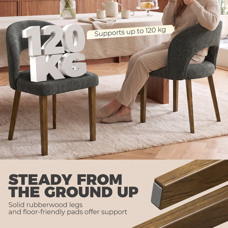 Dark grey dining chair with a 120 kg weight capacity label beside a woman seated at a table