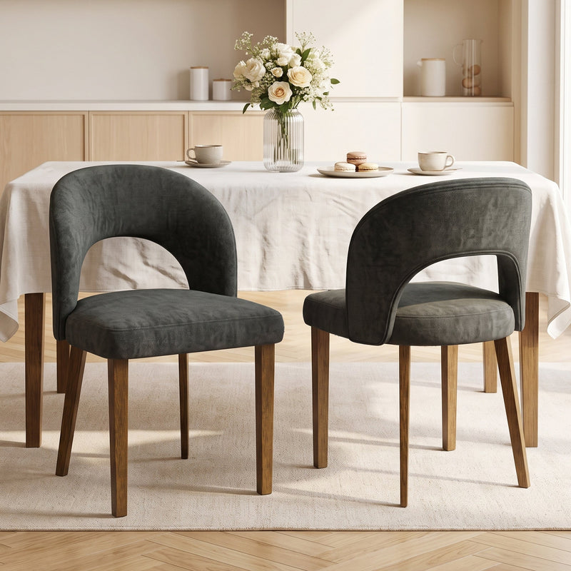 Two dark grey dining chairs at a table with flowers and tea cups