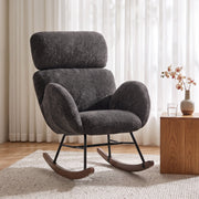 Dark grey velvet rocking chair beside a sheer curtain and side table in a living room