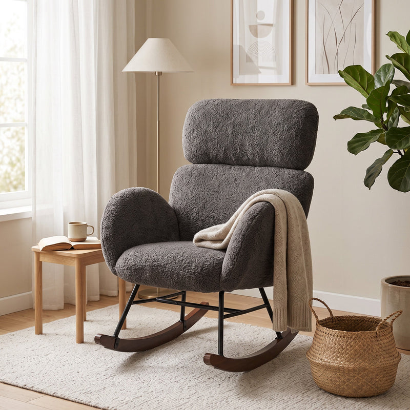 Dark grey rocking chair with a throw blanket beside a wooden side table and plant