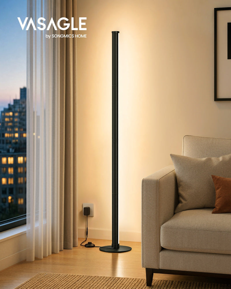 Vasagle by Songmics Home matte black floor lamp lit in a bedroom corner at dusk